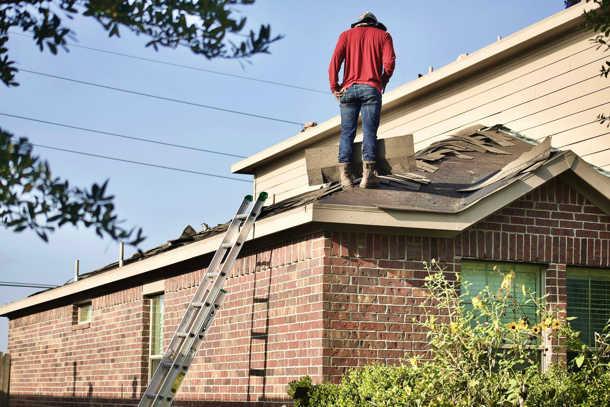 Asphalt shingle tear-off in progress during a residential roof replacement