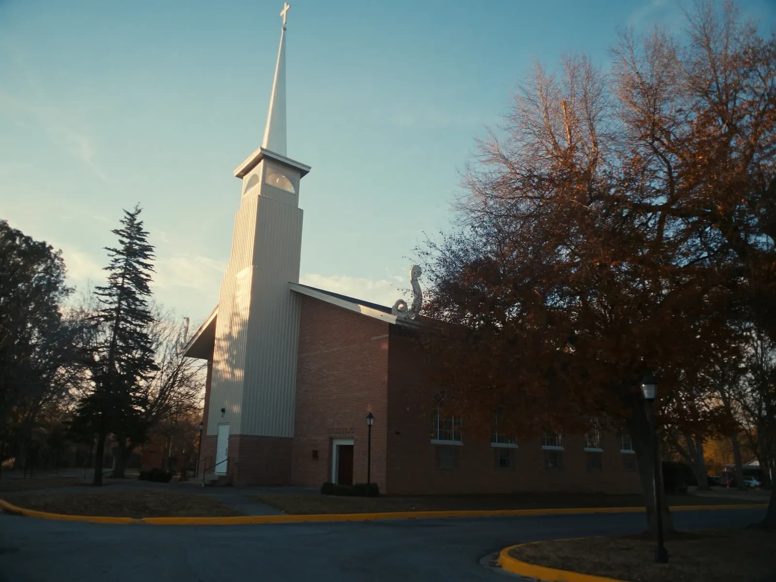 Brick church with a steep sanctuary roof and white steeple