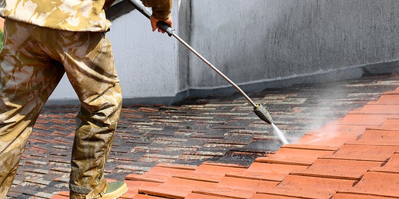 Washing a terracotta tile roof section on a commercial building