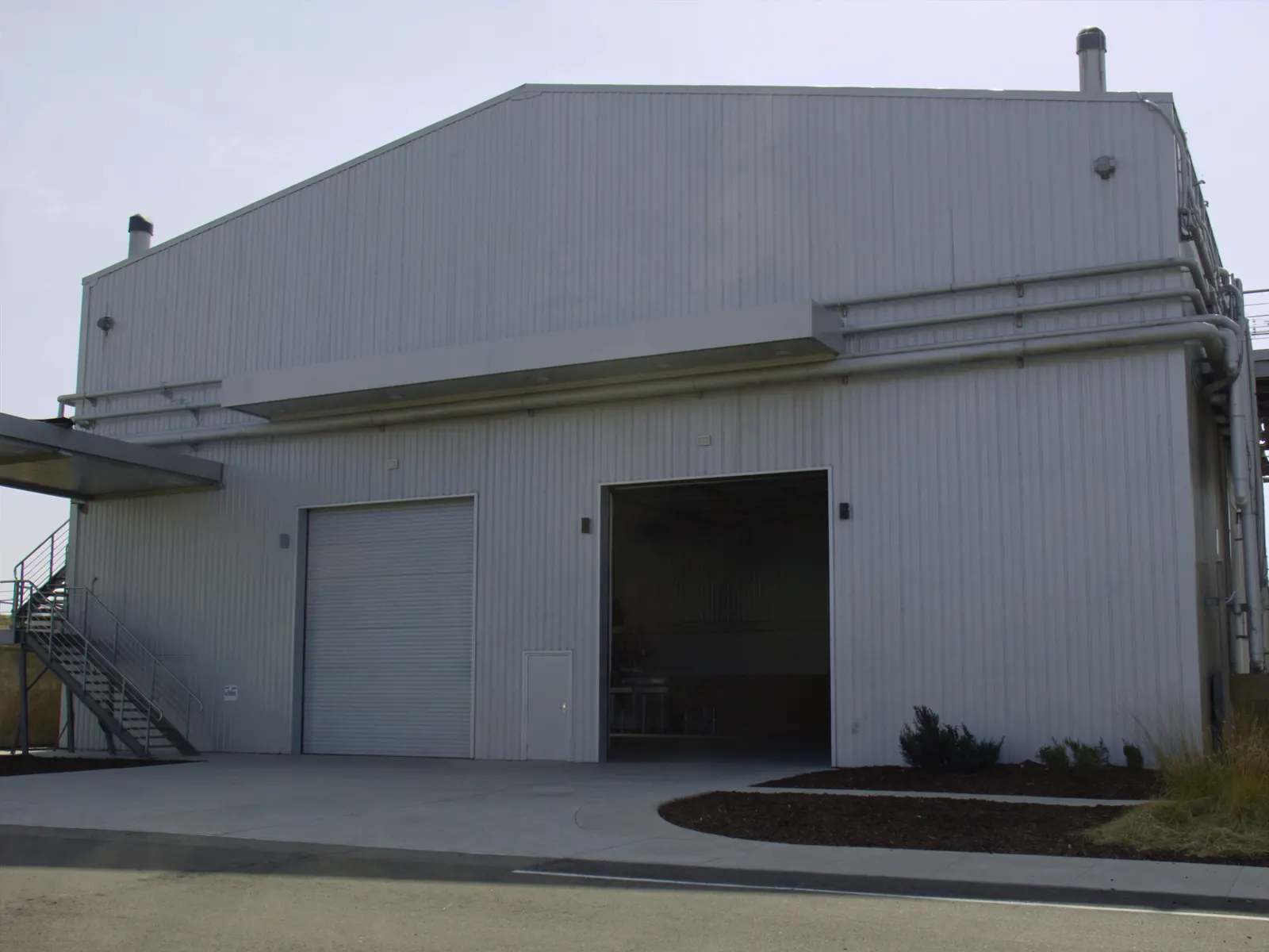 Manufacturing facility with a metal roof and tall bay doors