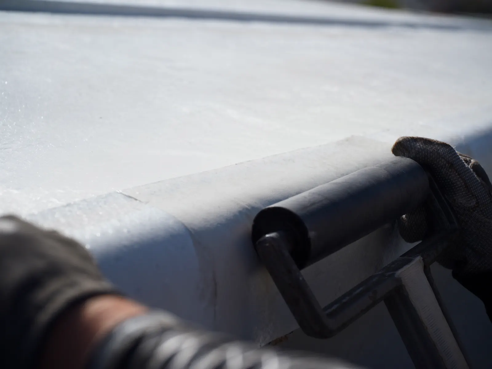 Heat-welding a repair patch on a white membrane roof