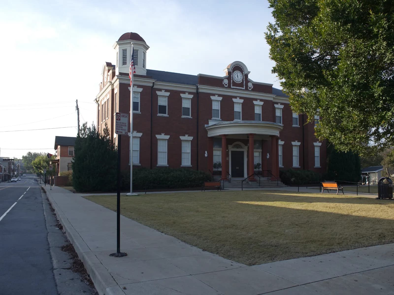 Brick civic building with columns and a flagpole
