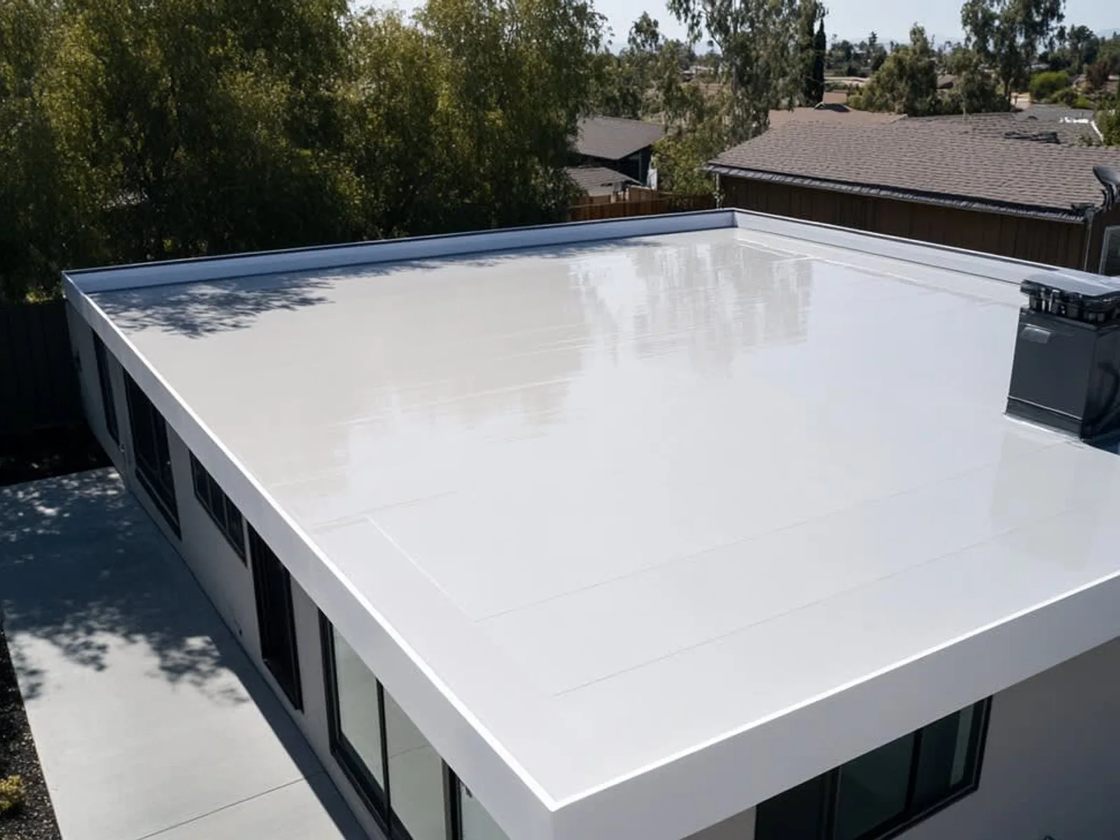 White PVC single-ply membrane roof in large welded sheets on a commercial building