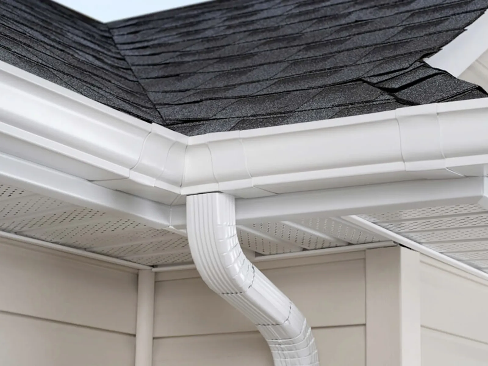 New white painted seamless metal gutter and downspout on a home