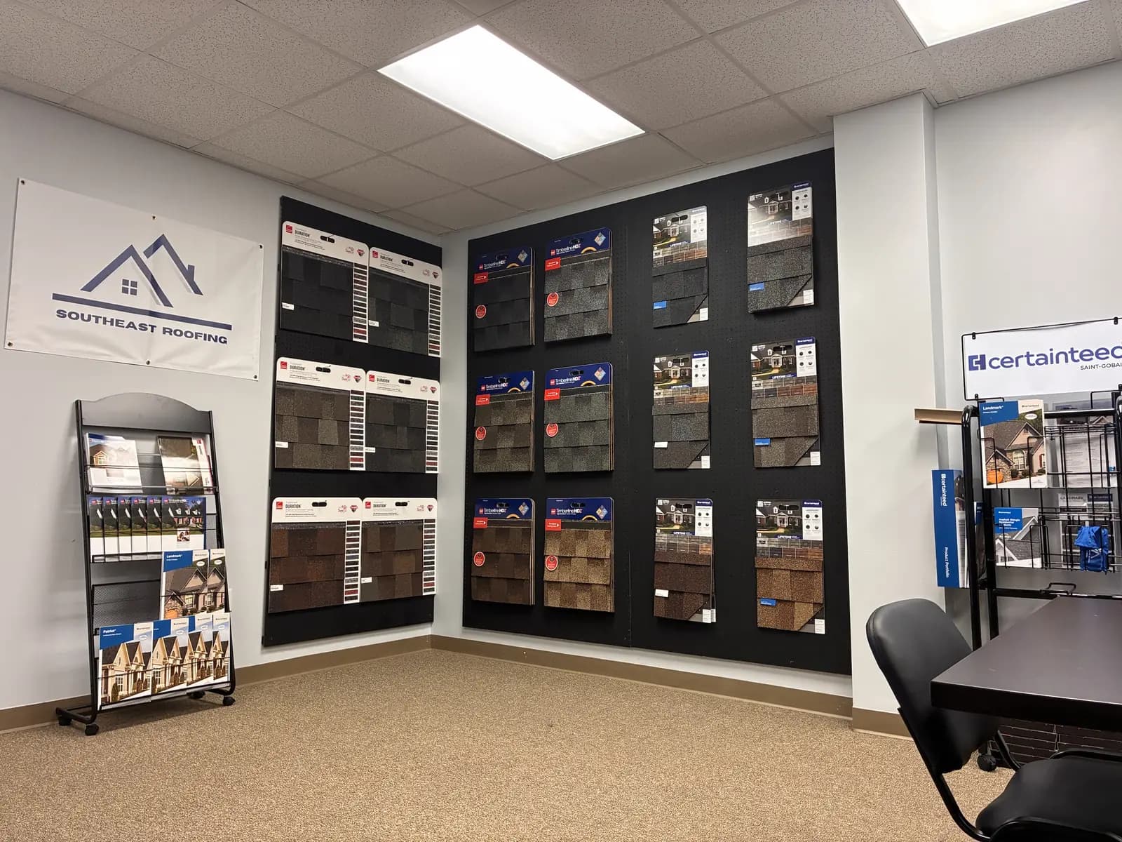 The showroom wall in Southeast Roofing's Hattiesburg office, hung with Owens Corning Duration, GAF Timberline HDZ and CertainTeed Landmark shingle sample boards.