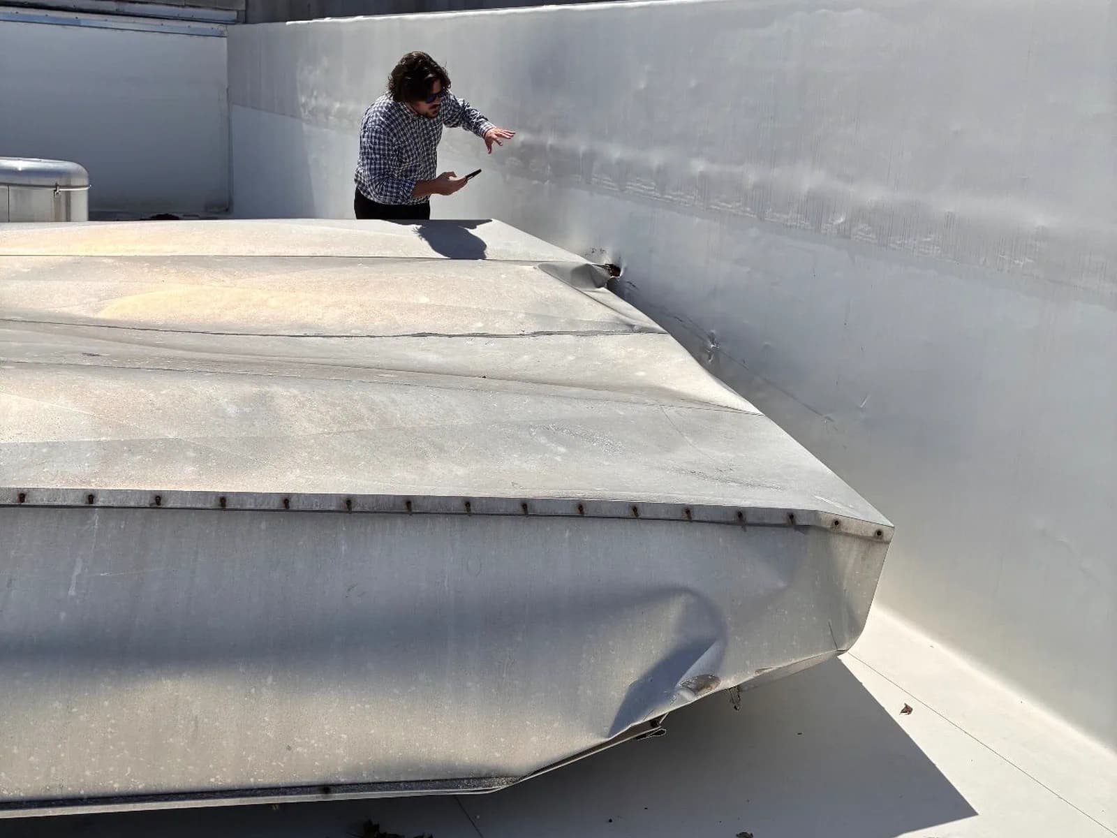 Southeast Roofing documenting wind damage to a rooftop equipment housing on a commercial membrane roof in Hattiesburg, Mississippi