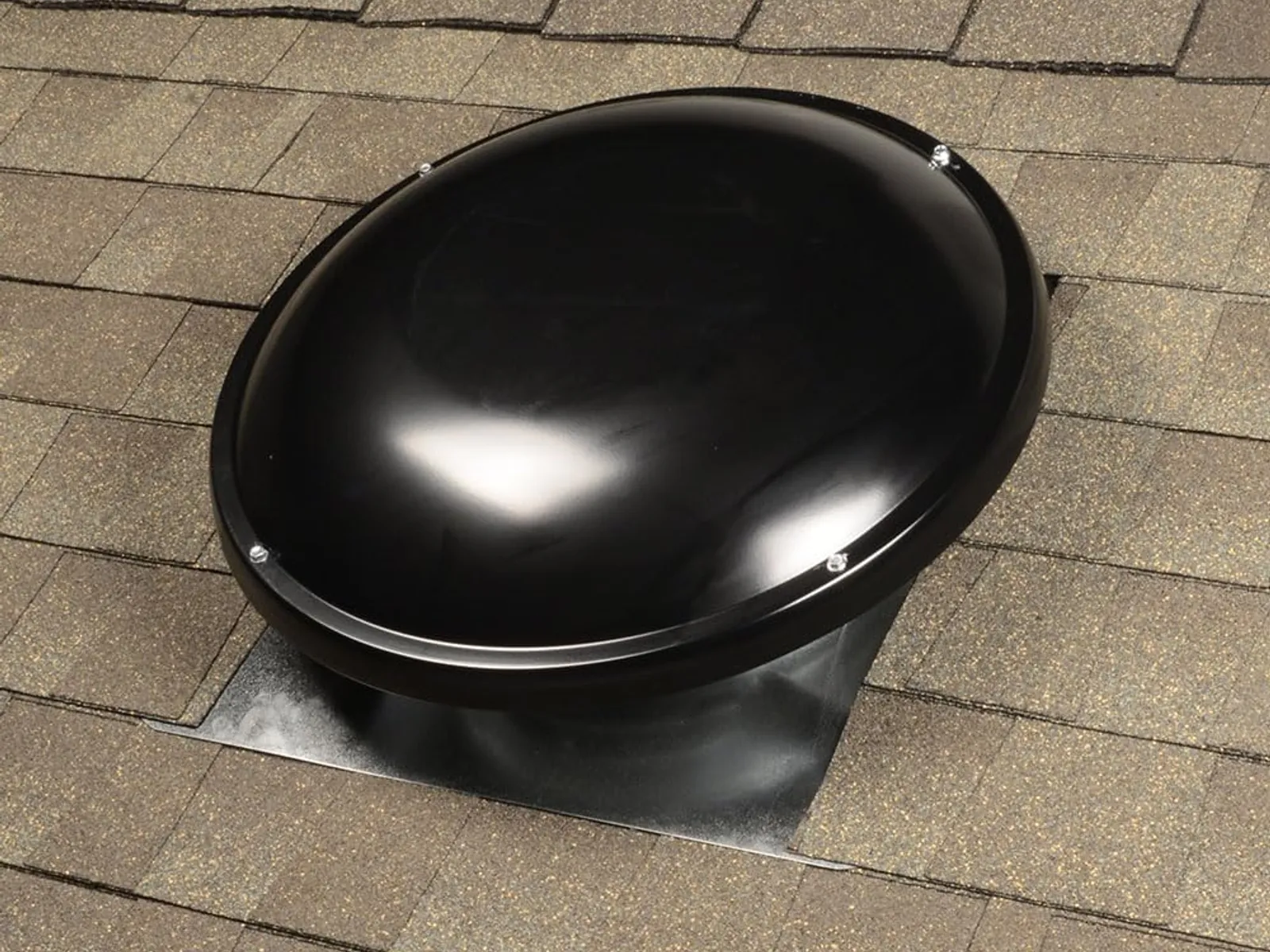 Powered attic fan vent mounted on a shingle roof