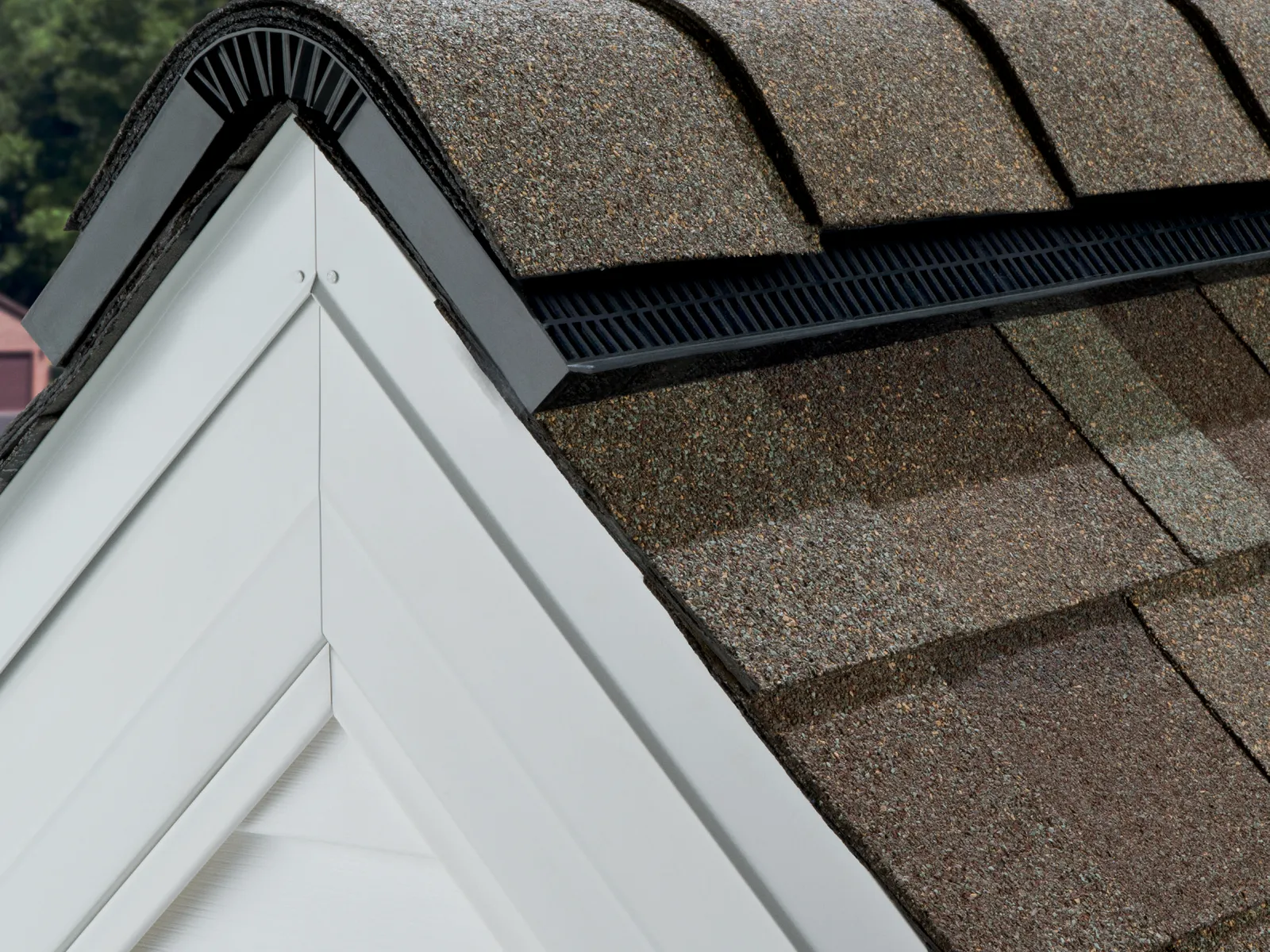 Black shingle-over ridge vent running the peak of an architectural shingle roof